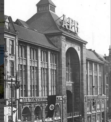 Historisches Gebäude mit großem AEG-Schild, Nazi-Flagge.