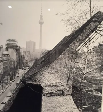 Betonplatte lehnt vor Stadtlandschaft.