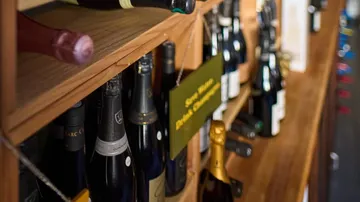 Weinflaschen auf Holzregalen im Laden.