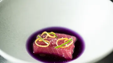 Rohes Thunfisch mit Garnierung in weißer Schüssel.