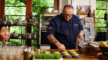 Chef prepares food on kitchen countertop.
