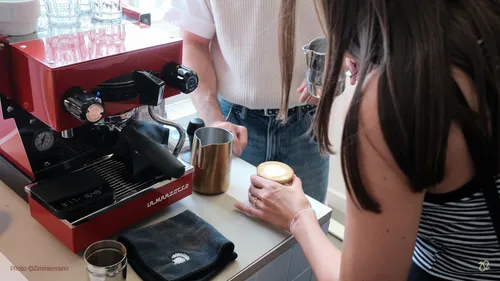 Personen machen Kaffee mit Espressomaschine.