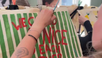 Person bemalt grün gestreifte Tasche.