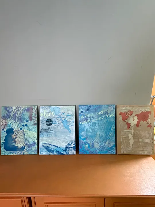 Vier dekorative Kunstleinwände auf Holzregal.