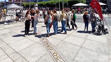 Group talking outside in sunny city square.