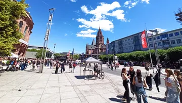 People gathering in sunny city square.
