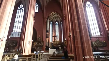 Kircheninneres, Menschen sitzen auf Bänken.