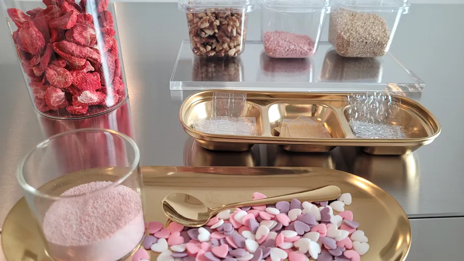 Bunte Zutaten und Beläge auf Metalltisch.