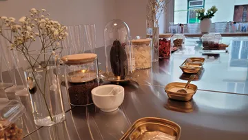 Verschiedene Gewürze und Gläser auf reflektierendem Tisch.