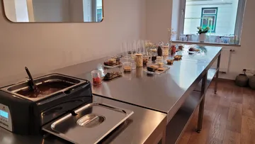 Schokoladenbrunnen und Toppings auf einem Tisch.