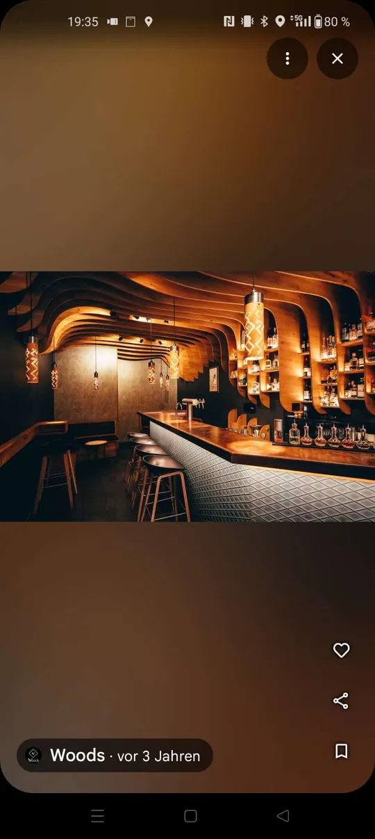 Moderne Bar mit Holzdecke und Hockern.