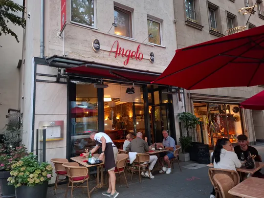 Kellnerin bedient Gäste vor charmantem Restaurant.