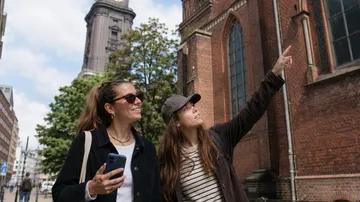 Zwei Frauen bewundern Backsteinkirche.