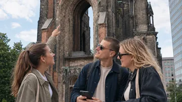 Drei Personen besichtigen historischen Kirchturm.
