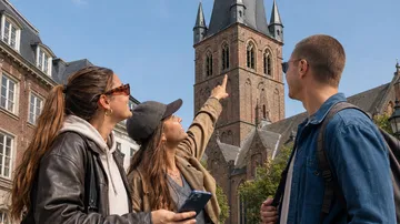 Drei Personen bewundern eine historische Kirche.