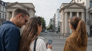 Drei Personen lesen Handy draußen in Stadtstraße.
