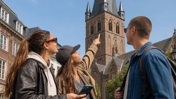 People pointing at a historic church tower.