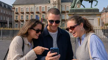Three people looking at smartphone outdoors.