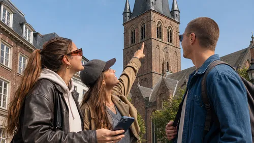 Three people admire a historic tower.