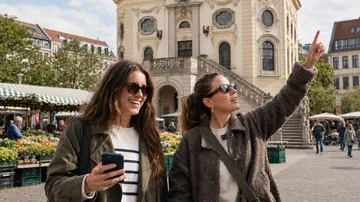 Two women sightseeing in a city square.