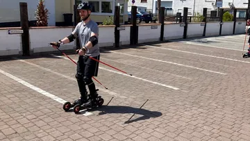 Person roller skiing in parking lot.
