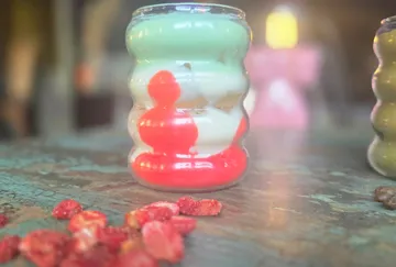 Colorful layered candle on rustic table.