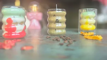 Three colorful candles on a table.