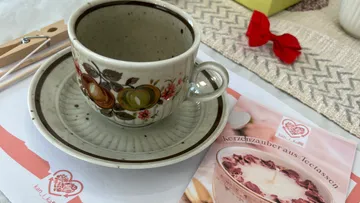 Keramik-Teetasse mit Blumendesign auf Untertasse.