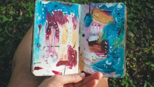 Art sketchbook open in outdoor setting.