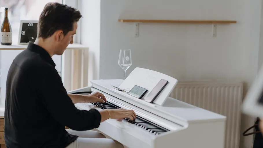 Person spielt Klavier in modernem Raum.