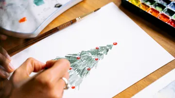 Hand painting Christmas tree on paper.