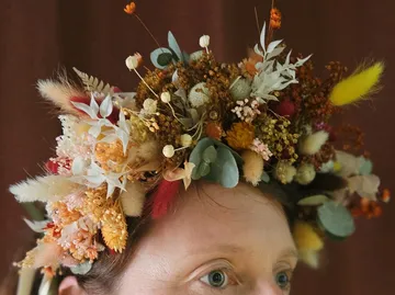 Head adorned with colorful dried flowers crown.