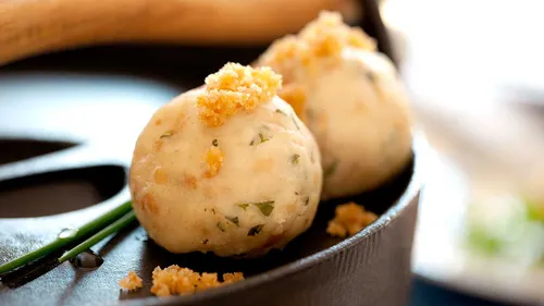 Bread dumplings with herbs on a pan.