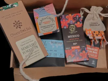 Sechs Schokoladenpackungen liegen in einer Kartonschachtel.