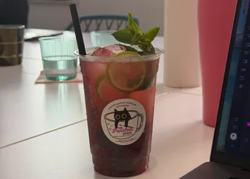 Eisgetränk mit Minze und Limette auf Tisch.