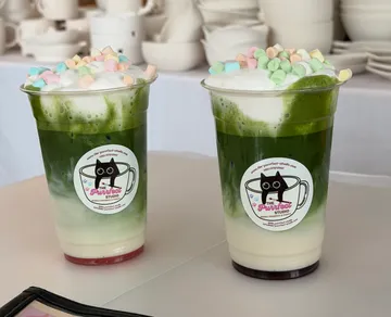 Zwei Matcha-Getränke mit Marshmallows, Tischdeko.