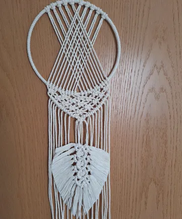 Macrame wall hanging on wooden door.
