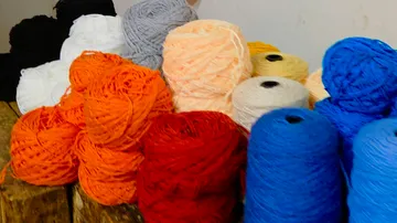 Multicolored yarn balls on a wooden table.
