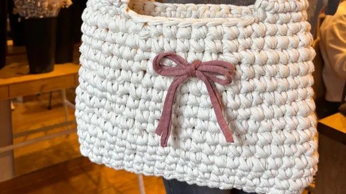 Gehäkelte weiße Tasche mit rosa Schleife, innen.