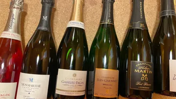 Champagnerflaschen vor Korkhintergrund ausgestellt.
