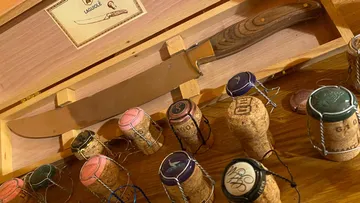 Knife displayed among champagne corks.