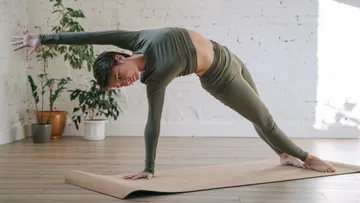 Person übt Seitstütz auf Yogamatte.