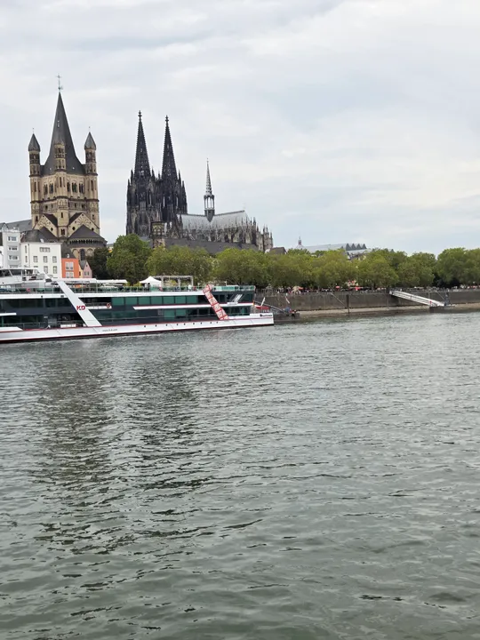 Boat on river with Cologne Cathedral backdrop.