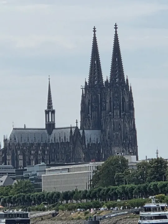 Gothic cathedral with twin spires overlooking river.