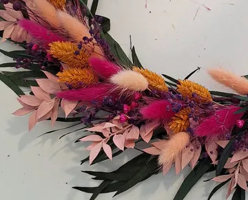 Bunte Trockenblumen-Arrangements auf einem Tisch.