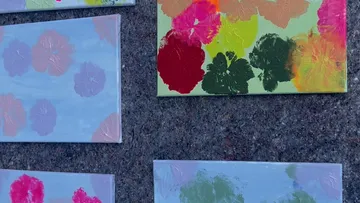Bunte Blumengemälde im Freien ausgestellt.