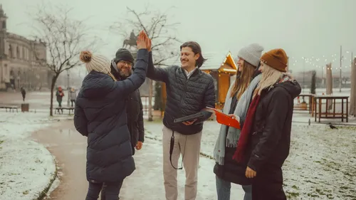 Group high-fiving in snowy outdoor setting.