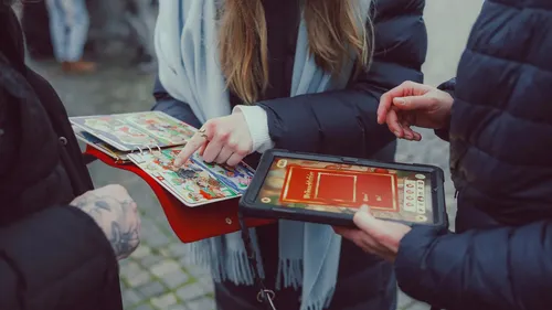 Hände zeigen auf Tablet draußen.