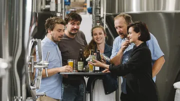Gruppe untersucht Bier in Brauerei.