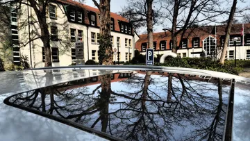 Gebäude spiegelt sich auf Autodach.